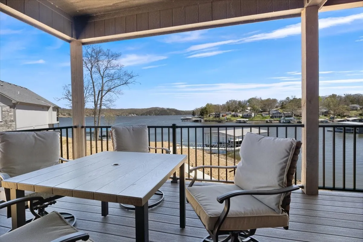This image highlights an outdoor dining table set with comfortable seating and a panoramic lake view. Trees frame the background, and the setup invites thoughts of sunrise breakfasts, lakeside dinners, or gathering with friends and family to enjoy nature.